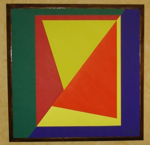 Obra geométrica enmarcada: borde verde y azul, un plano rojo, un trapecio amarillo y un triángulo naranja, sobre una pared ocre.